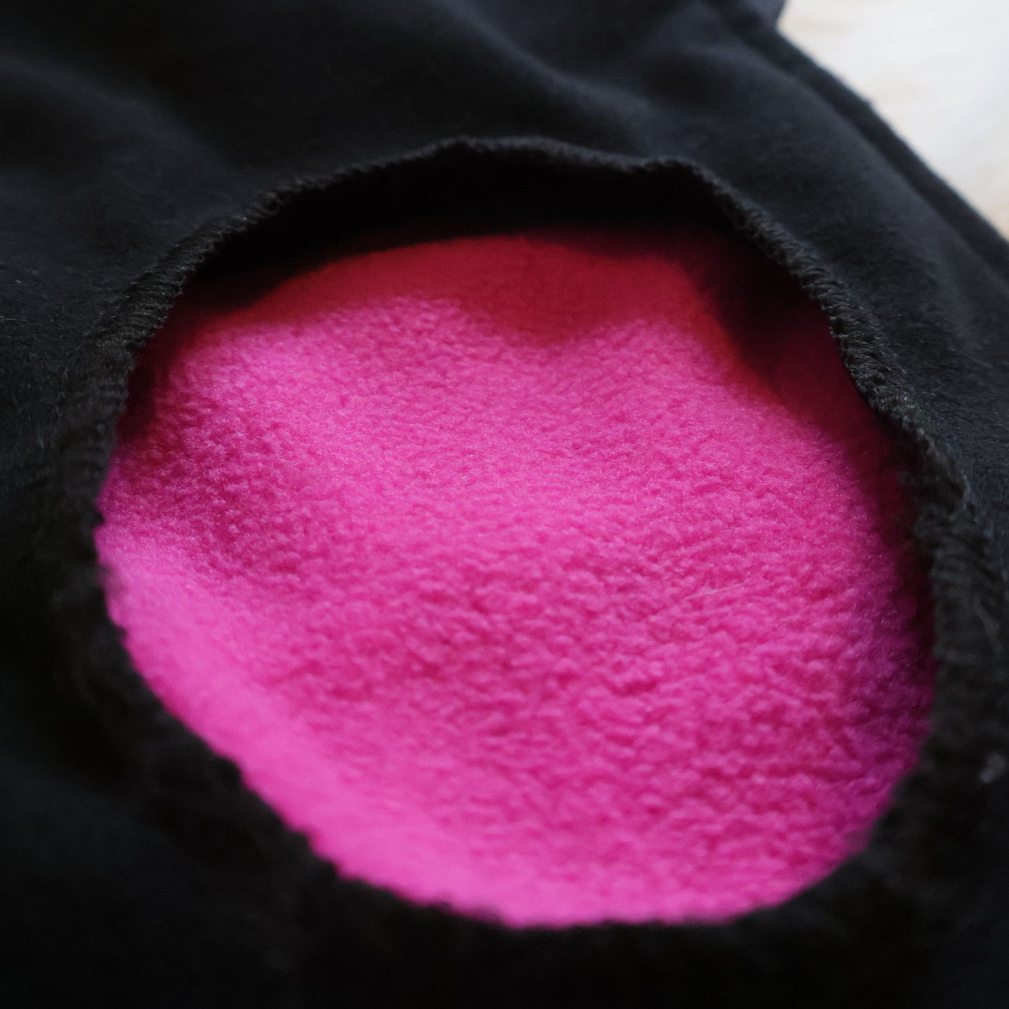 Close-up of a pink textured fabric inside a black fabric.