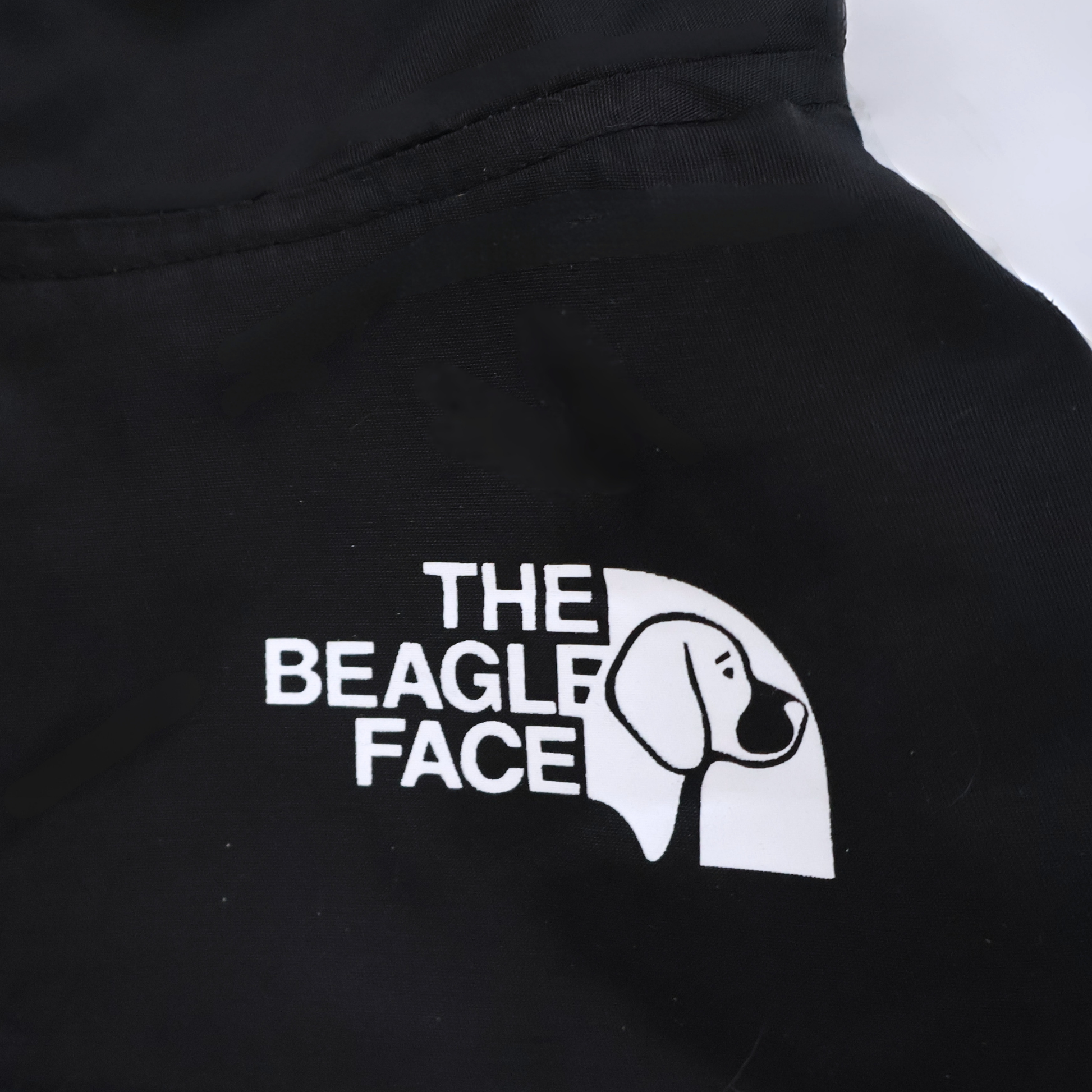 Black jacket with 'The Beagle Face' logo on a white background