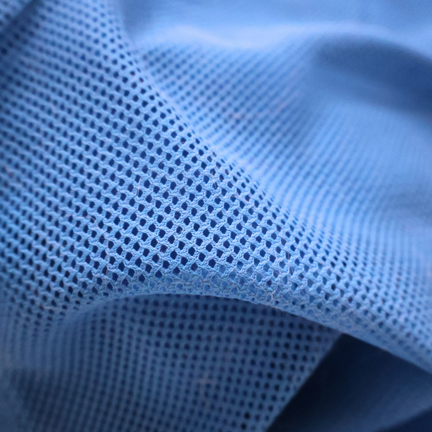 Close-up of blue textured mesh fabric with a grid pattern