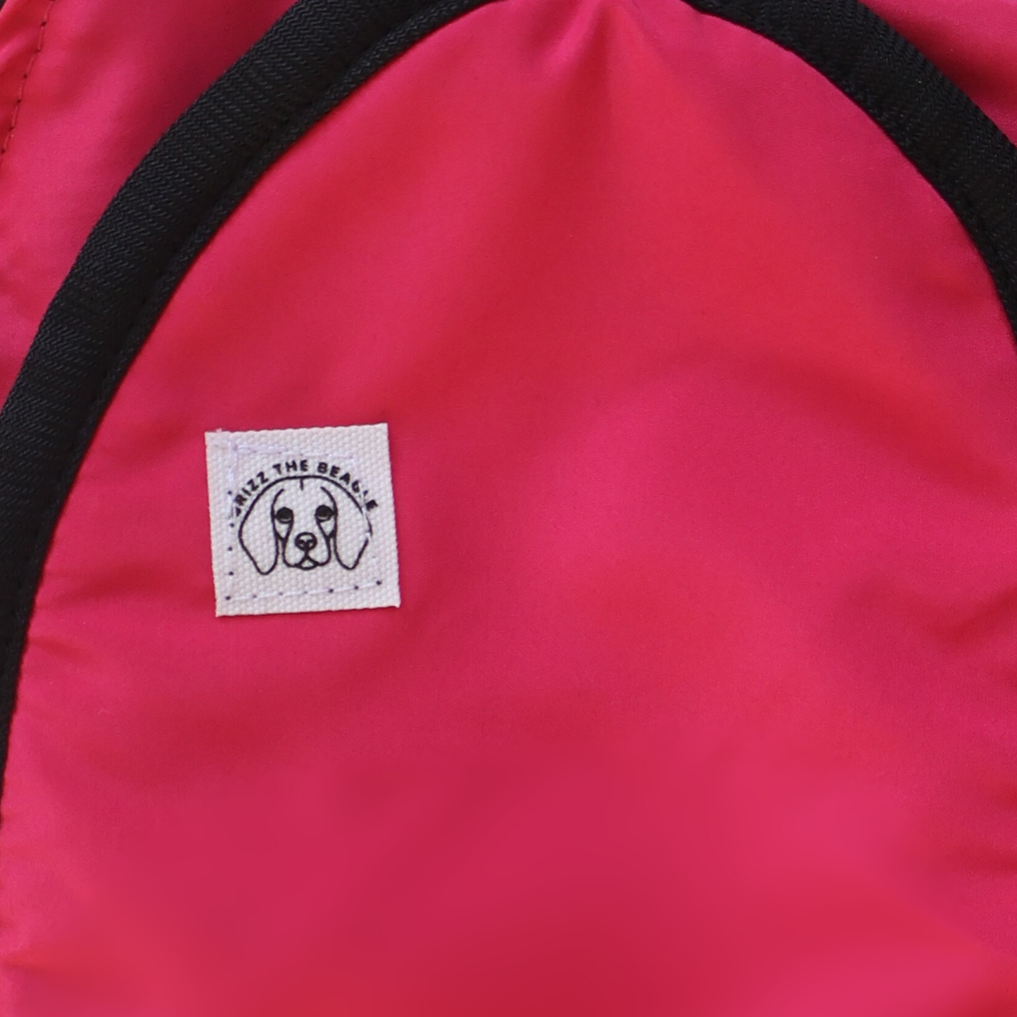 Close-up of a pink Rosy Trail ear muffs featuring a dog illustration and text.